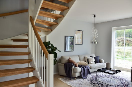 Stylish Scandinavian living room featuring a wooden staircase, cozy sofa, and modern decor.